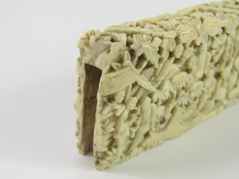 A Cantonese late 19thC ivory card sleeve, carved with figures in a garden, 7cm x 3.5cm, (AF). - Image 2 of 2