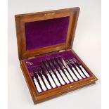 A set of twelve late 19thC / early 20thC silver plated dessert knives and forks, in a fitted oak