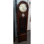 An early-mid 20thC oak longcase timepiece, the circular silvered dial above a aneroid barometer, the