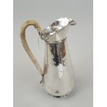 A 19thC silver plated Britannia metal hot water jug, of tapering form, with woven handle.