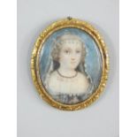 A portrait brooch, the watercolour of a girl in evening dress, on gilt metal frame.