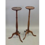 A pair of George III style torcheres, each with a shaped top and a faceted column and tripod base,