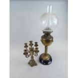 Two items of brass, a column oil lamp with wide opaque stencilled shade and a five branch