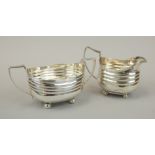 A George V silver two handled sugar bowl, with reeded decoration and bun feet, and an associated