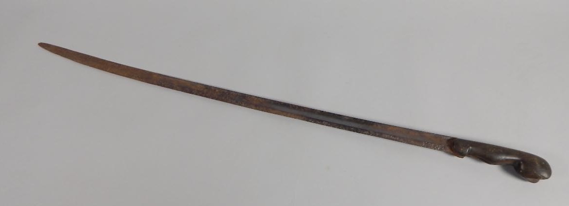 A late 19thC/early 20thC African sword, with an iron blade, the handle possibly shaped from rhino