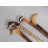 A collection of four late 20thC walking sticks, each with a carved handle in the form of a fox, (