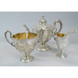 A Victorian silver three piece tea set, of urn form, with a pineapple finial, engraved overall