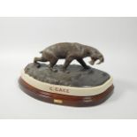A bronze model of a sabre tooth tiger by Carl Gage, on composition stone and mahogany plinth,