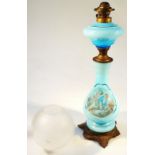 A late 19thC overlay blue glass lamp, with metal fittings, the bulbous body printed with a scene