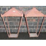 A pair of painted metal lanterns, each with domed square tops on slender supports with square bases,