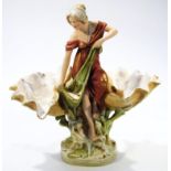 An early 20thC Royal Dux centrepiece, formed as a lady in flowing robes on a naturalistic base,