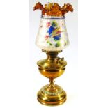 An early 20thC brass oil lamp, with highly decorative tapering shade in frosted, painted and clear