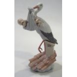 A modern Lladro figure group, of a stork and baby on a roof top, printed marks beneath, 30cm high.