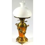 An early 20thC brass oil lamp, in the oriental manner, with clear glass reservoir and milk glass