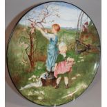 A 19thC decorative pottery charger, initialled MS, set with a figure of a girl picking blossom