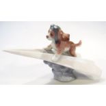 A Lladro figure group, of a puppy riding paper aeroplane, no. 6665, marks beneath, 20cm wide.