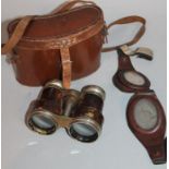 A pair of brown leather flying goggles and field binoculars, with chrome plated articulated centres,