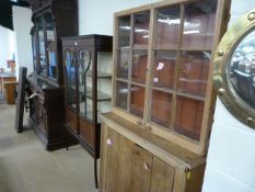 A pine cupboard with glazed bookcase over