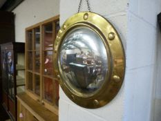 A brass porthole convex mirror