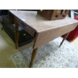 An oak drop leaf table with drawer under
