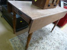 An oak drop leaf table with drawer under