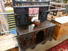 A heavily carved oak mirrored cupboard