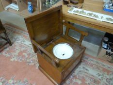 An Edwardian commode with fold up arms