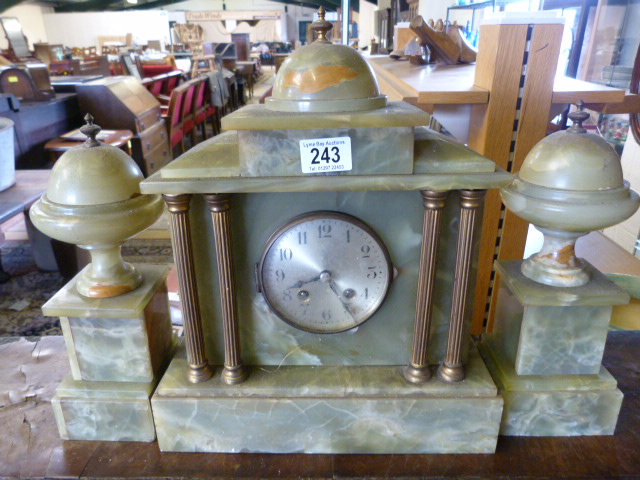 An Onyx mantle clock with garniture