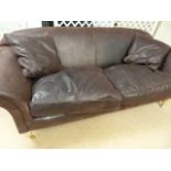 A Large brown leather sofa with beech legs