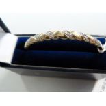 A 9ct hinged bangle set with diamonds - total weight 9.8g