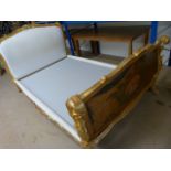 A large ornate gilt bed with painted ends