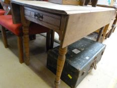 An oak drop leaf table with drawer under