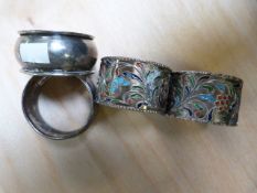 Two enamelled silver napkin rings and two others