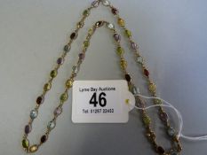 A 9ct chain decorated with various semi precious stones- Peridot, Amethyst,Topaz, Aquamarine etc.