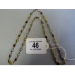 A 9ct chain decorated with various semi precious stones- Peridot, Amethyst,Topaz, Aquamarine etc.