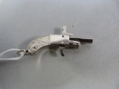 A Fully working miniature hammer action pin fire pistol with folding octagonal barrel, scroll