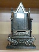 A cast iron money box in the form of a throne by Harper, commemorating the coronation in 1953