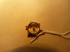 A gold coloured metal compass pendant