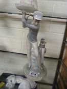 A Lladro figure of a boy playing golf