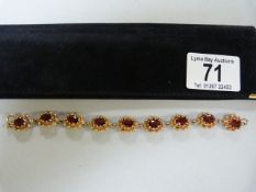 A 9 ct gold bracelet set with garnets, 1 extra link- total weight 18.9g