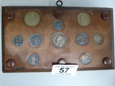 A wallmounted plaque with various coins