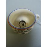 A miniature chamber pot with a picture of Hitler on the inside, marked " Flip your ashes on old