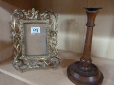 An ornate brass photo frame and an inlaid oak candlestick