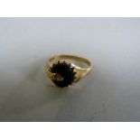 A 9 ct gold ring with a snake crawling over an onyx stone ( 1 eye missing)