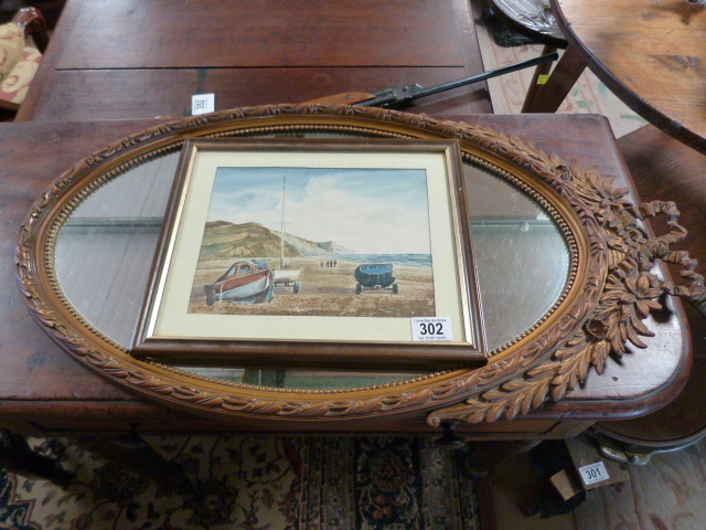 A gilt framed oval mirror and a watercolour of a beach scene