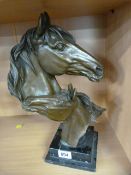 A modern bronze of a horses head with a foal