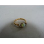 A diamond and opal three stone ring set in 18ct gold, size N, total weight 2.6g