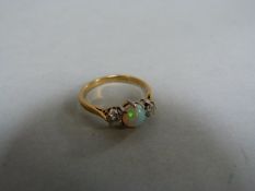 A diamond and opal three stone ring set in 18ct gold, size N, total weight 2.6g