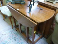 An oak drop leaf table on square tapering legs