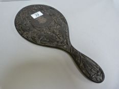 A heavily carved ebony dressing table mirror with silver coloured monogram- chip to mirror